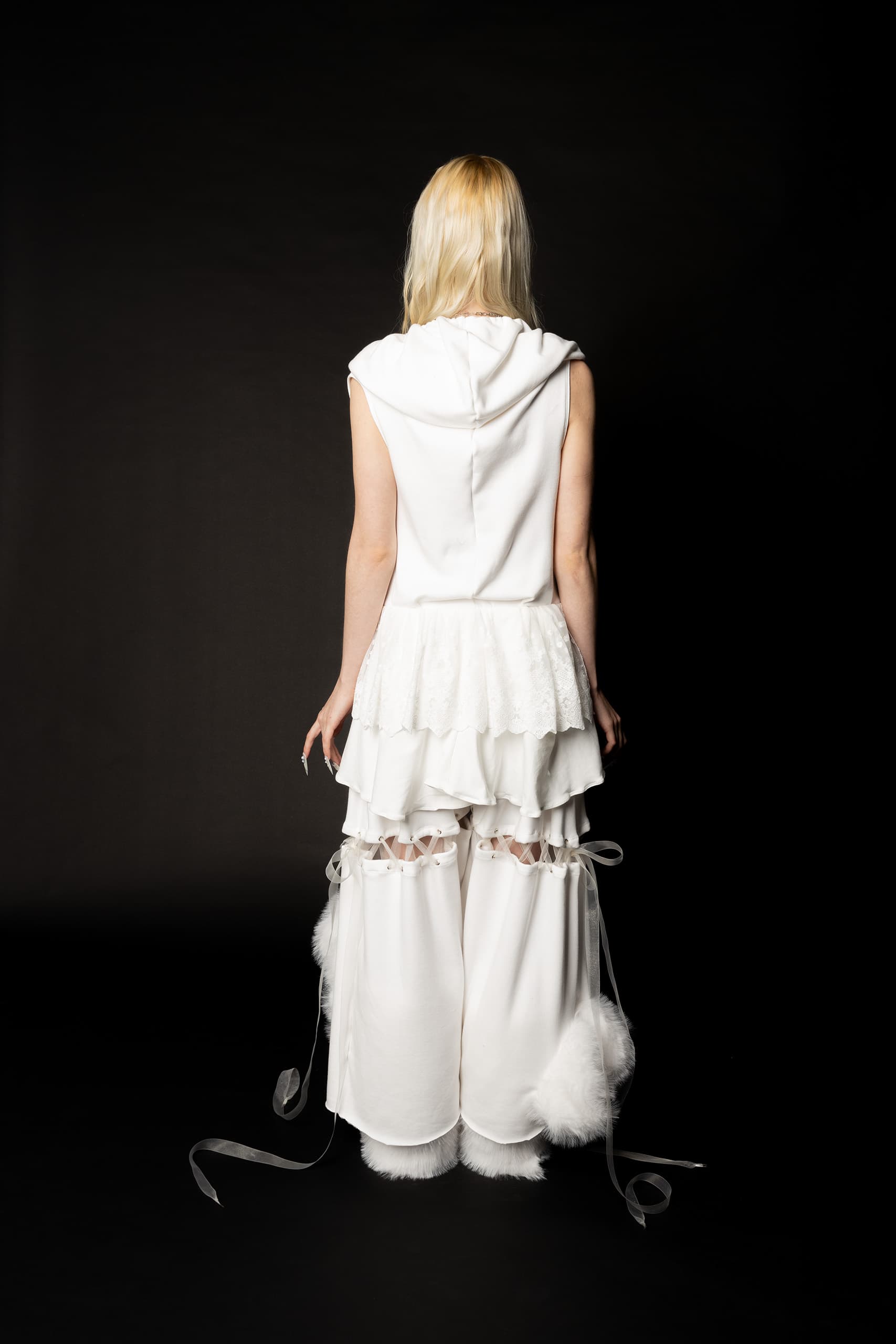 © 2026 Linh Chi Nguyen & Thanh Van Nguyen — Rear view of the white sleeveless hoodie with lace ruffles and ribbon trouser details.