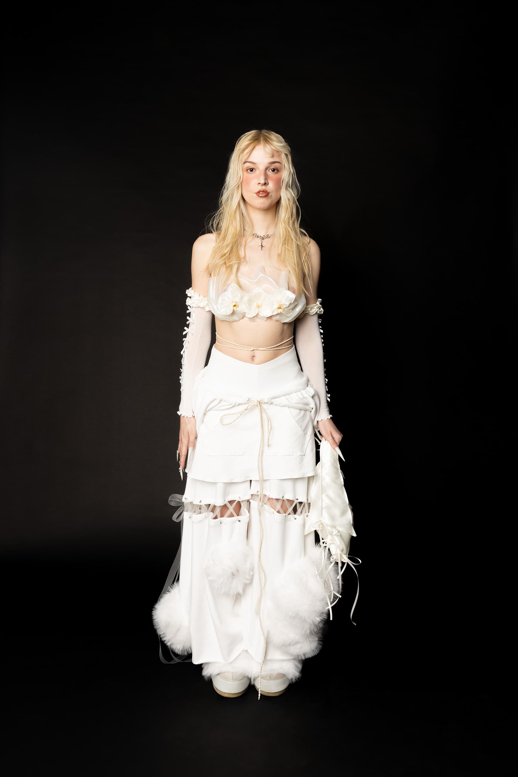 © 2026 Linh Chi Nguyen & Thanh Van Nguyen — Full body studio shot of the white floral orchid bustier and tiered fur trousers.