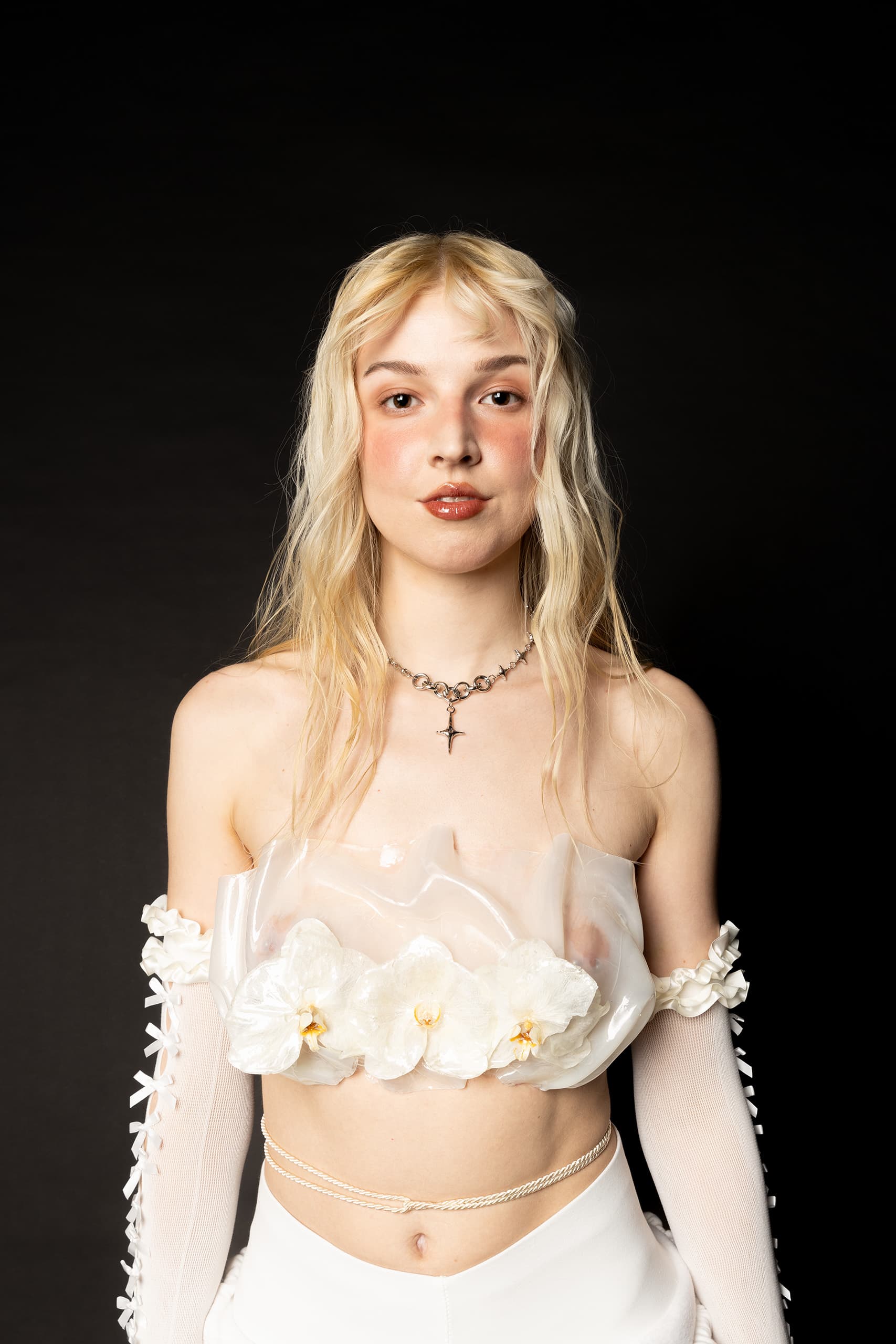 © 2026 Linh Chi Nguyen & Thanh Van Nguyen — Portrait showcasing the translucent floral orchid bustier and silver cross necklace.